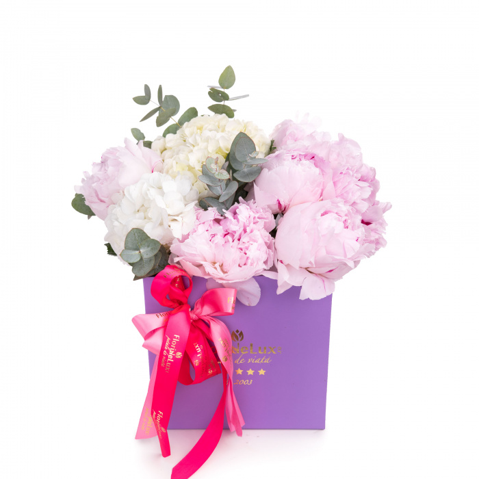 Vedere de ansamblu a produsului Aranjament floral cu bujori si hortensii, varianta Deluxe, compusa din 7 bujori roz, o crenguta de eucalipt si 2 hortensii albe