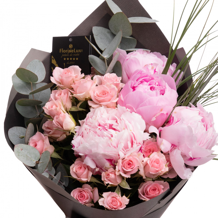 Detaliu de aproape cu florile din Buchet bujori roz Heart's Desire, varianta Deluxe, compusa din 7 fire de beargrass, 4 bujori roz, 2 crengute de eucalipt, 4 trandafiri ramificati roz