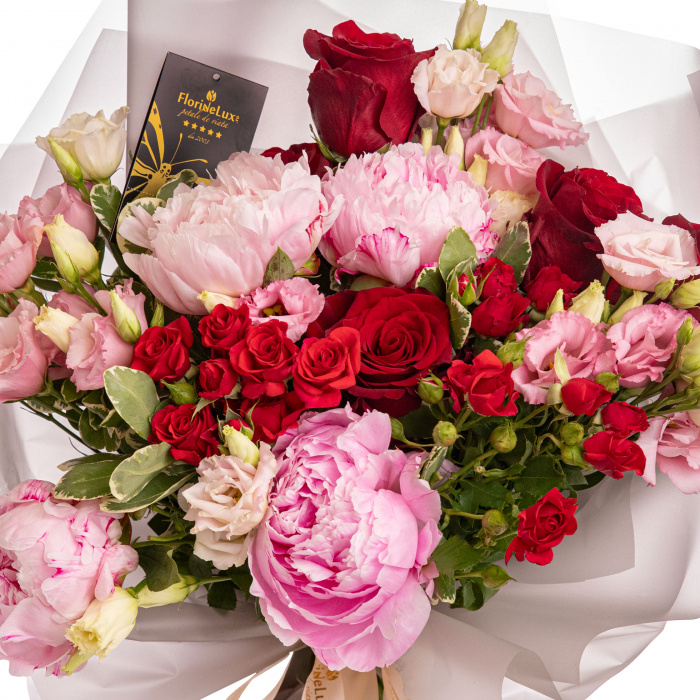 Detaliu de aproape cu florile din Buchet bujori si trandafiri rosii, varianta Premium, compus din 4 bujori roz, 3 flori de lisianthus roz, 3 crengute de pittosporum, 3 trandafiri ramificati rosii, 5 trandafiri rosii