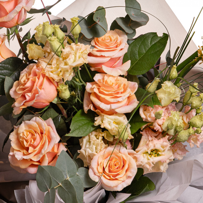 Detaliu de aproape cu florile din Buchet trandafiri portocalii, varianta Premium, compus din 7 trandafiri portocalii, 2 ornitogalum, 3 eustoma somon, 2 eucalipt, 3 salal, 3 beargrass.
