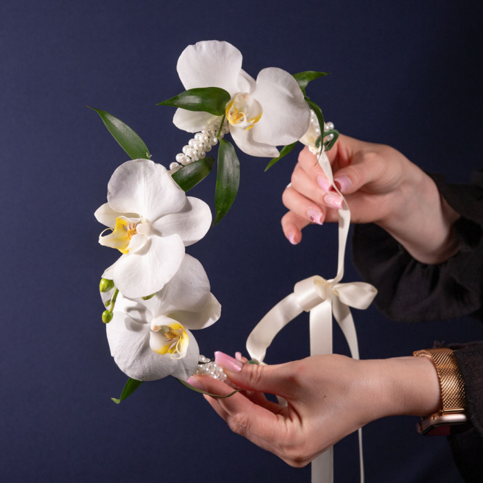 Perspectiva cu florile din Coronita cu orhidee albe, varianta Standard, compusa din o jumatate de fir de orhidee phalaenopsis si o crenguta de ruscus mic