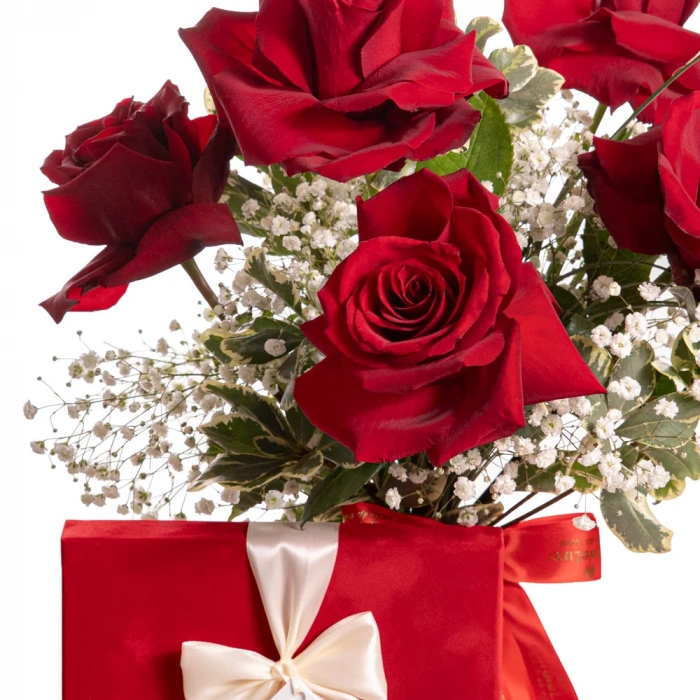 Detaliu de aproape cu florile din Buchet cu trandafiri rosii si ciocolata, varianta Standard, compus din 1 cutie de praline de ciocolata belgiana Hamlet Velvet, 5 trandafiri rosii, 3 fire de gypsophila, 5 fire de beargrass si 2 crengute de pittosporum.