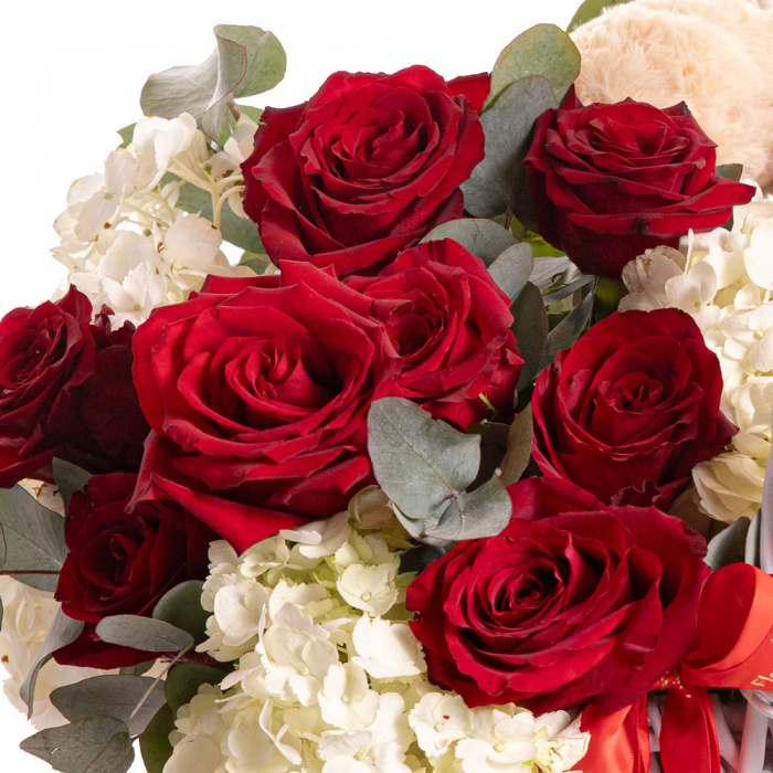 Detaliu de aproape cu florile din Cos cadou Luxury Gifts&Treats, varianta Standard, compus din 3 hortensii albe, 11 trandafiri rosii si 6 crengute de eucalipt