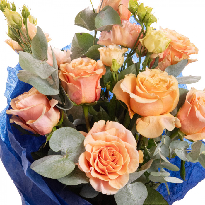 Detaliu de aproape cu florile din Buchet cu flori portocalii, varianta Deluxe, compus din 7 trandafiri portocalii, 2 flori de lisianthus somon si 3 crengute de eucalipt