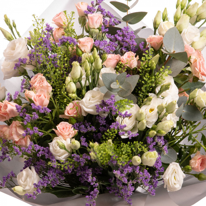 Detaliu de aproape cu florile din Buchet cu lisianthus, trandafiri si limonium, varianta Premium, compusa din 4 fire de lisianthus alb, 2 crengute de limonium mic, 2 crengute de lepidium, 3 trandafiri ramificati roz, 1 crenguta de eucalipt