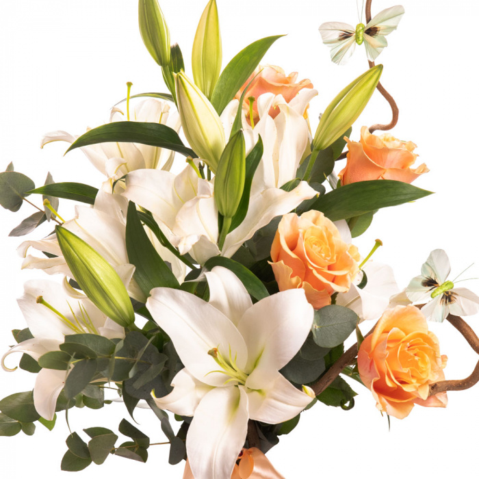 Detaliu de aproape cu florile din Buchet crini si trandafiri portocalii, varianta Deluxe, compusa din 4 trandafiri portocalii, 3 crini orientali albi, 3 crengute de eucalipt si 1 crenguta de corylus