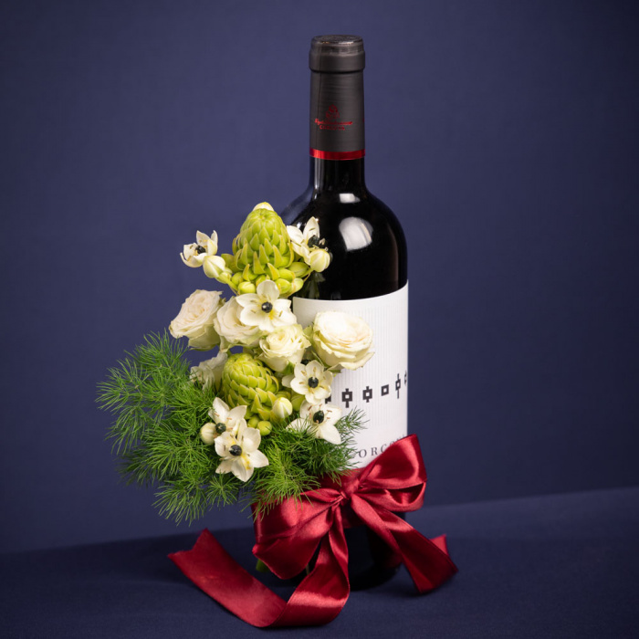 Vedere de ansamblu a produsului Vin Corcova cu aranjament floral, compus din 1 sticla de vin rosu Corcova, 2 fire de ornitogalum, 1 fir de trandafir ramificat alb si 1 fir de asparagus umbelatus