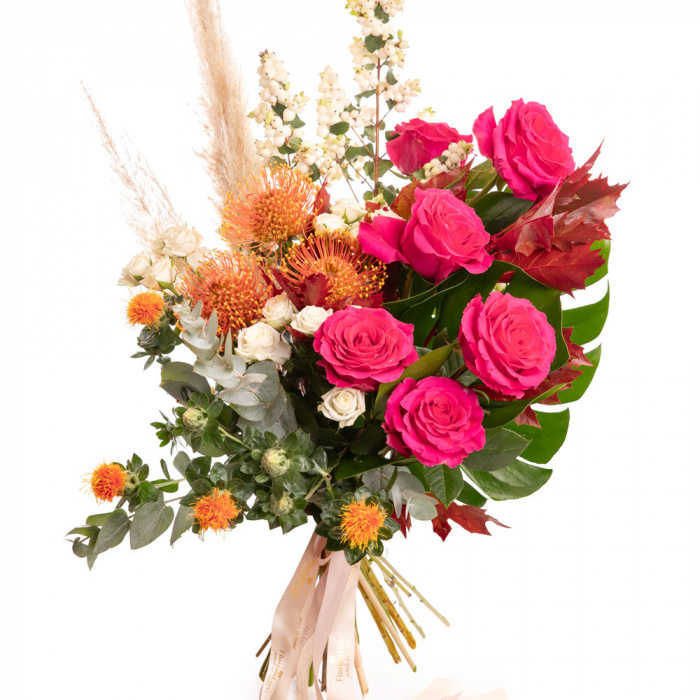 Vedere de ansamblu a produsului Buchet de toamna exotic, varianta Deluxe, compus din 2 frunze de monstera, 2 fire de pampas, 2 crengute de symphoricarpos, 3 flori de leucospermum, 3 flori de carthamus, 6 trandafiri Pink Floyd, 3 trandafiri ramificati albi si 2 crengute de quercus